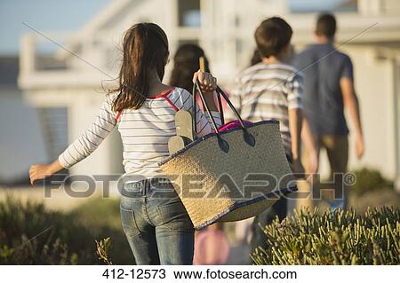 Girl with beach bag following family View Large Photo Image Stock Image - Girl with beach bag following family. Fotosearch