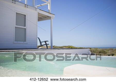 Infinity pool and beach house overlooking ocean View Large Photo Image Stock Image - Infinity pool and beach house overlooking ocean. Fotosearch
