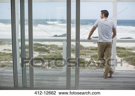 Man looking at ocean view from deck View Large Photo Image Stock Image - Man looking at ocean view from deck. Fotosearch
