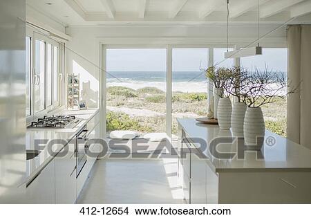 Modern white kitchen with ocean view View Large Photo Image Picture - Modern white kitchen with ocean view. Fotosearch