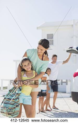 Mother and daughter hugging in sunny driveway View Large Photo Image Stock Photography - Mother and daughter hugging in sunny driveway. Fotosearch