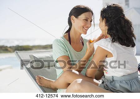 Picture - Mother and daughter relaxing at poolside. Fotosearch