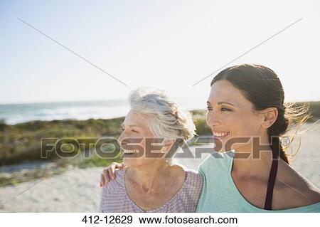 Stock Photo - Mother and daughter smiling on sunny beach. Fotosearch