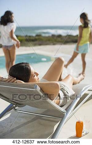 Mother and daughters relaxing at poolside View Large Photo Image Stock Photo - Mother and daughters relaxing at poolside. Fotosearch