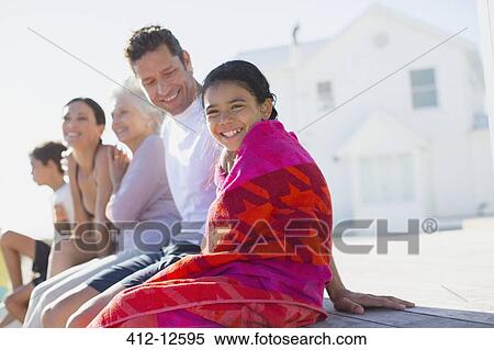 Stock Photography - Multi-generation family sitting outside beach house. Fotosearch