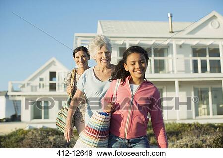 Multi-generation women walking on beach path outside house View Large Photo Image Stock Photo - Multi-generation women walking on beach path outside house. Fotosearch