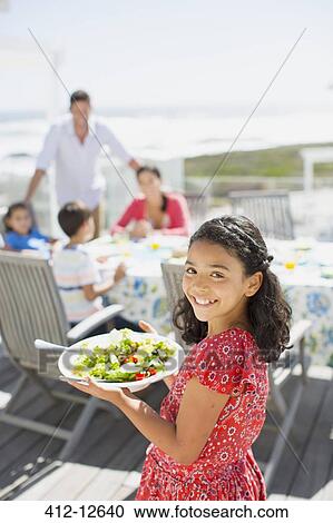 Smiling girl carrying salad bowl on sunny patio View Large Photo Image Stock Image - Smiling girl carrying salad bowl on sunny patio. Fotosearch