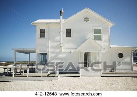 White beach house against blue sky View Large Photo Image Stock Photo - White beach house against blue sky. Fotosearch