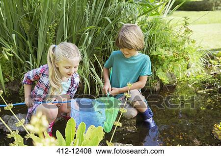 Stock Photo - Children fishing together in pond. Fotosearch