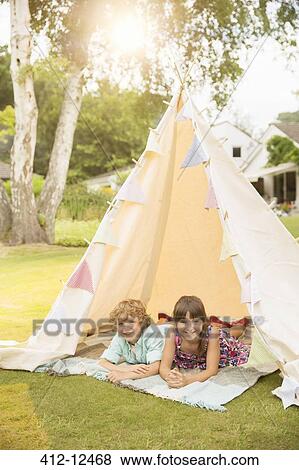 Children laying in teepee in backyard View Large Photo Image Stock Photo - Children laying in teepee in backyard. Fotosearch