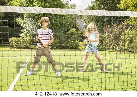 Children playing tennis on grass court View Large Photo Image Stock Photo - Children playing tennis on grass court. Fotosearch