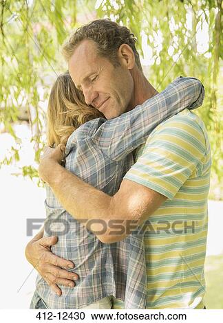 Stock Image - Couple hugging outdoors. Fotosearch