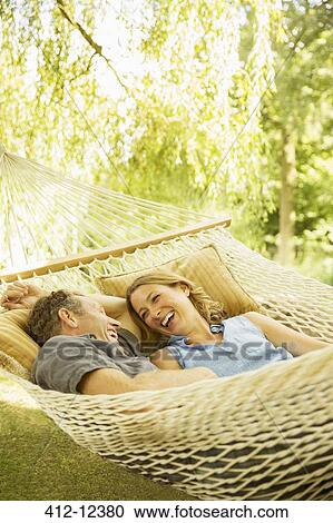 Couple relaxing in hammock outdoors View Large Photo Image Stock Image - Couple relaxing in hammock outdoors. Fotosearch