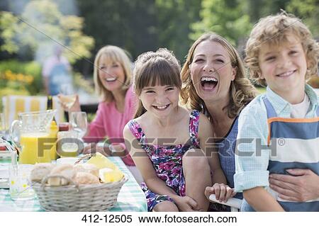 Family at table in backyard View Large Photo Image Stock Photography - Family at table in backyard. Fotosearch