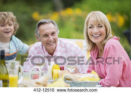 Family eating together outdoors View Large Photo Image Stock Image - Family eating together outdoors. Fotosearch