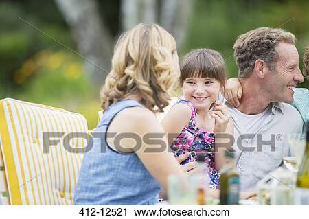 Stock Image - Family eating together outdoors. Fotosearch