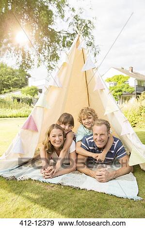 Family relaxing in teepee in backyard View Large Photo Image Stock Photo - Family relaxing in teepee in backyard. Fotosearch