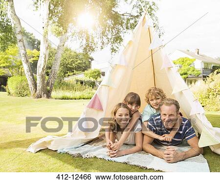 Family relaxing in teepee in backyard View Large Photo Image Stock Photograph - Family relaxing in teepee in backyard. Fotosearch