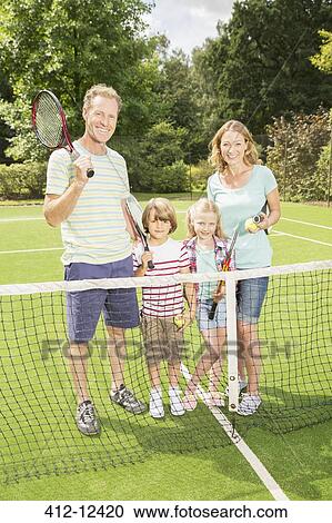 Family smiling together on grass tennis court View Large Photo Image Stock Image - Family smiling together on grass tennis court. Fotosearch