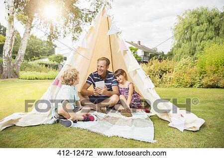 Father and children relaxing in teepee in backyard View Large Photo Image Stock Image - Father and children relaxing in teepee in backyard. Fotosearch
