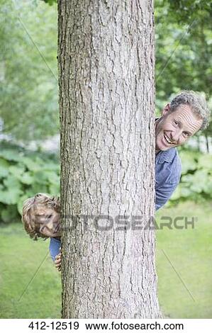 Father and son peering from behind tree View Large Photo Image Stock Photo - Father and son peering from behind tree. Fotosearch