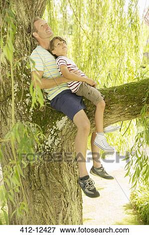 Stock Photo - Father and son relaxing in tree. Fotosearch