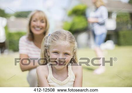 Stock Photo - Granddaughter and grandmother smiling outdoors. Fotosearch