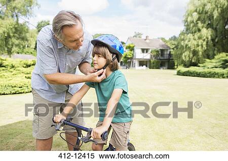 Grandfather adjusting bicycle helmet on grandson View Large Photo Image Stock Photography - Grandfather adjusting bicycle helmet on grandson. Fotosearch