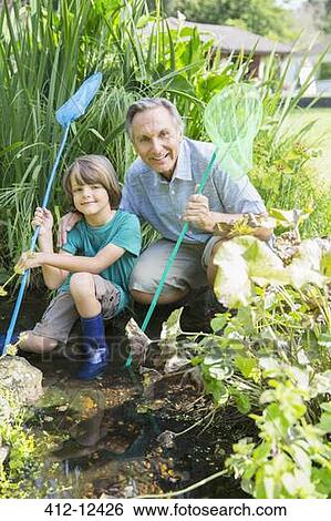 Stock Photograph - Grandfather and grandson fishing in pond. Fotosearch