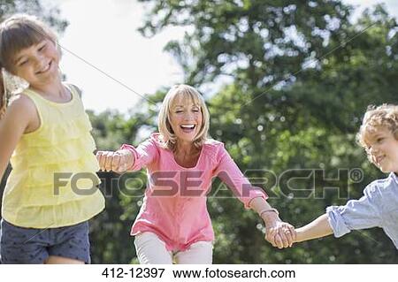 Stock Photo - Grandmother and grandchildren playing outdoors. Fotosearch