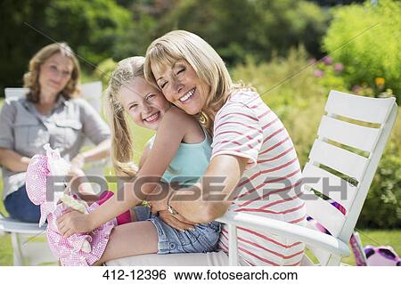Grandmother and granddaughter hugging in backyard View Large Photo Image Stock Photograph - Grandmother and granddaughter hugging in backyard. Fotosearch