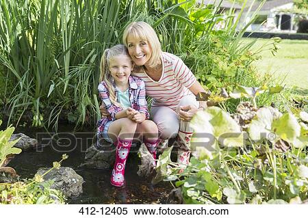 Grandmother and granddaughter smiling by pond View Large Photo Image Stock Photography - Grandmother and granddaughter smiling by pond. Fotosearch