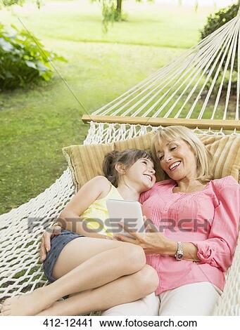 Grandmother and granddaughter with digital tablet in hammock View Large Photo Image Stock Image - Grandmother and granddaughter with digital tablet in hammock. Fotosearch