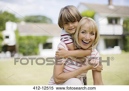 Stock Photography - Grandmother and grandson hugging in backyard. Fotosearch