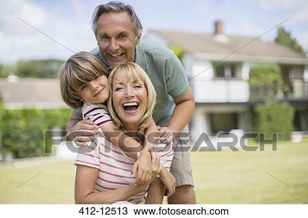 Grandparents and grandson hugging in backyard View Large Photo Image Stock Image - Grandparents and grandson hugging in backyard. Fotosearch