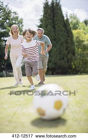 Stock Photo - Grandparents and grandson playing soccer. Fotosearch