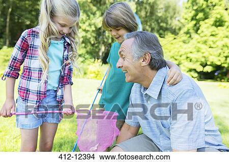 Picture - Man and grandchildren playing outdoors. Fotosearch
