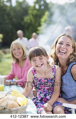 Mother and daughter laughing at table in backyard View Large Photo Image Stock Photo - Mother and daughter laughing at table in backyard. Fotosearch