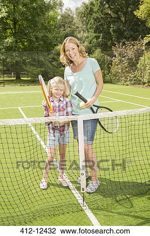 Mother and daughter smiling on grass tennis court View Large Photo Image Stock Image - Mother and daughter smiling on grass tennis court. Fotosearch