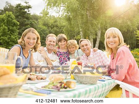 Multi-generation family enjoying lunch at table in backyard View Large Photo Image Stock Image - Multi-generation family enjoying lunch at table in backyard. Fotosearch