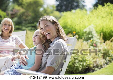 Stock Photo - Multi-generation women laughing in backyard. Fotosearch