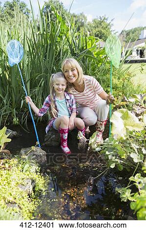 Woman and granddaughter fishing in pond View Large Photo Image Stock Image - Woman and granddaughter fishing in pond. Fotosearch