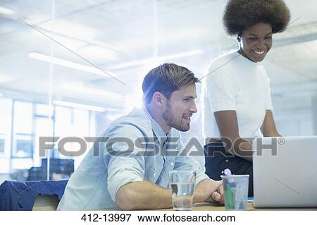 Business people using laptop in office View Large Photo Image Stock Photo - Business people using laptop in office. Fotosearch