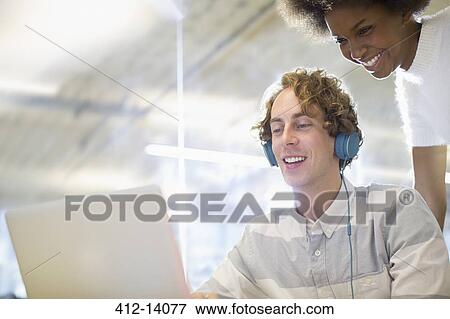 Stock Photo - Business people using laptop in office. Fotosearch