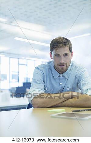 Businessman sitting at desk in office View Large Photo Image Stock Image - Businessman sitting at desk in office. Fotosearch