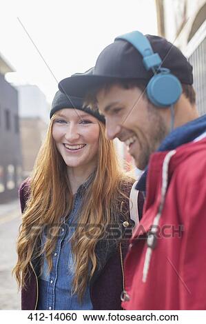 Couple laughing together on city street View Large Photo Image Stock Image - Couple laughing together on city street. Fotosearch