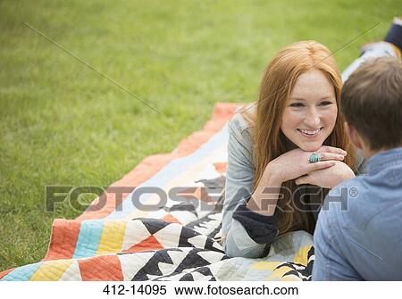 Couple relaxing on blanket in park View Large Photo Image Stock Photography - Couple relaxing on blanket in park. Fotosearch