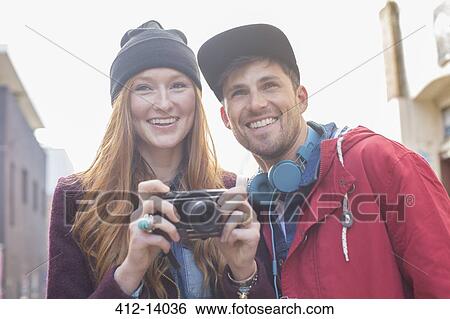 Stock Photograph - Couple taking photographs with camera in city. Fotosearch