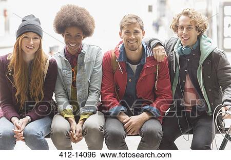 Friends smiling on urban bench View Large Photo Image Stock Photograph - Friends smiling on urban bench. Fotosearch