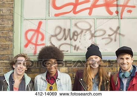 Friends smiling together in front of graffiti window View Large Photo Image Stock Photo - Friends smiling together in front of graffiti window. Fotosearch